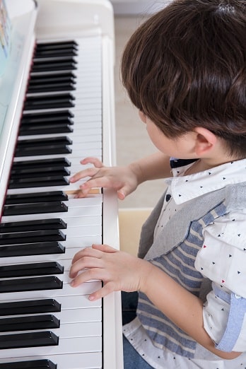 child studying piano