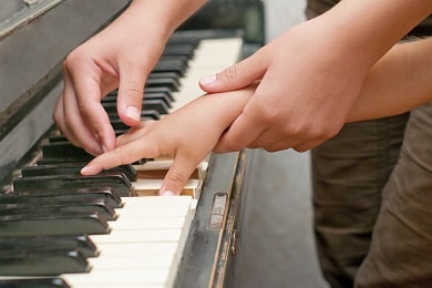 piano teacher helping student